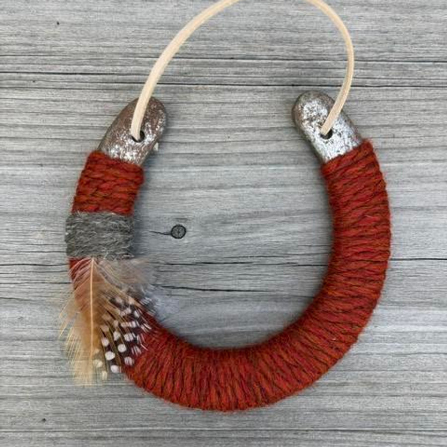 Rust wool-wrapped lucky horseshoe with feathers